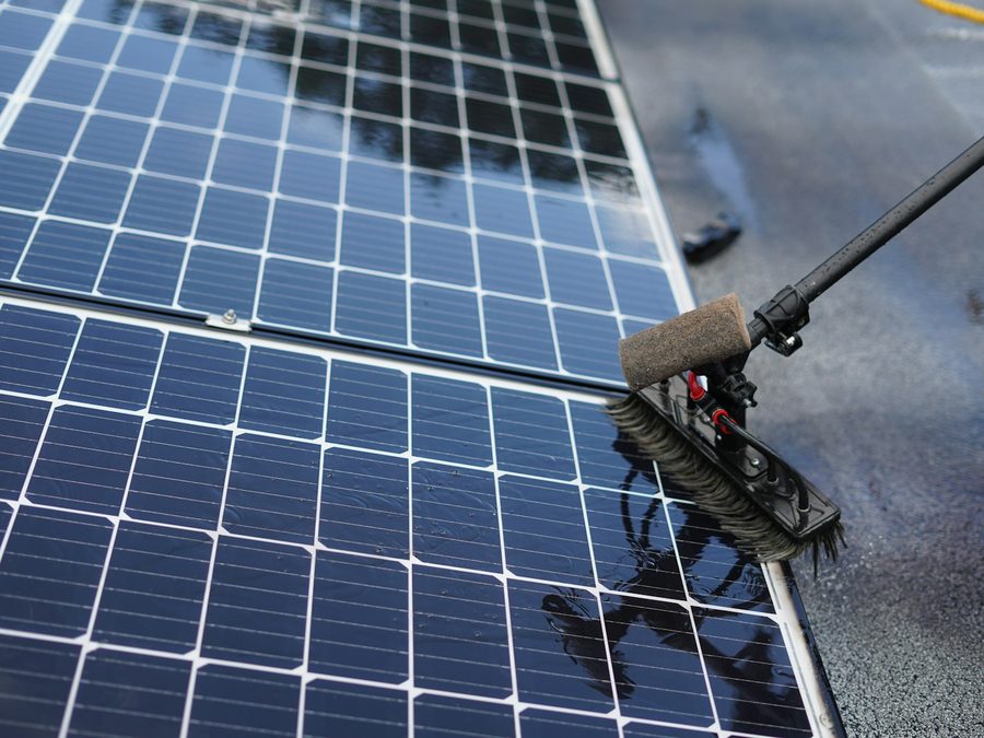 Zonnepanelen worden met een zachte borstel aan een lange steel gereinigd